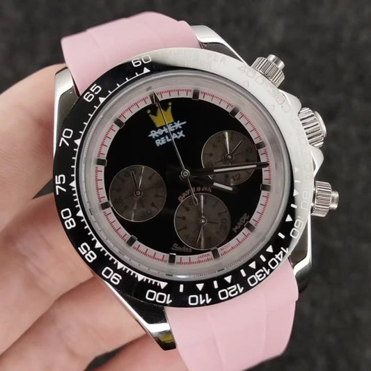 Watch with pink strap held in a hand against a dark textured background